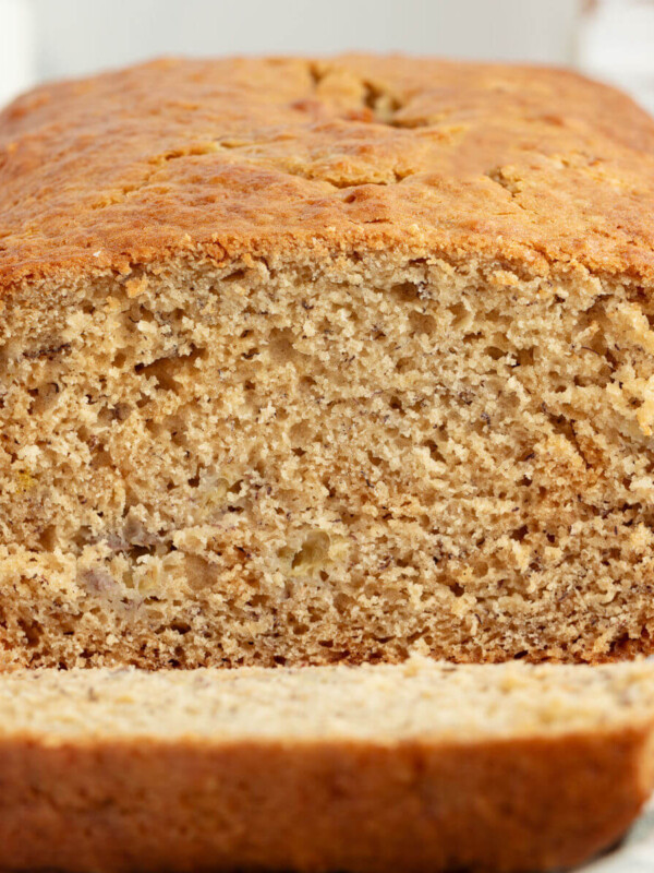 Loaf of sourdough banana bread with one slice cut out of it.