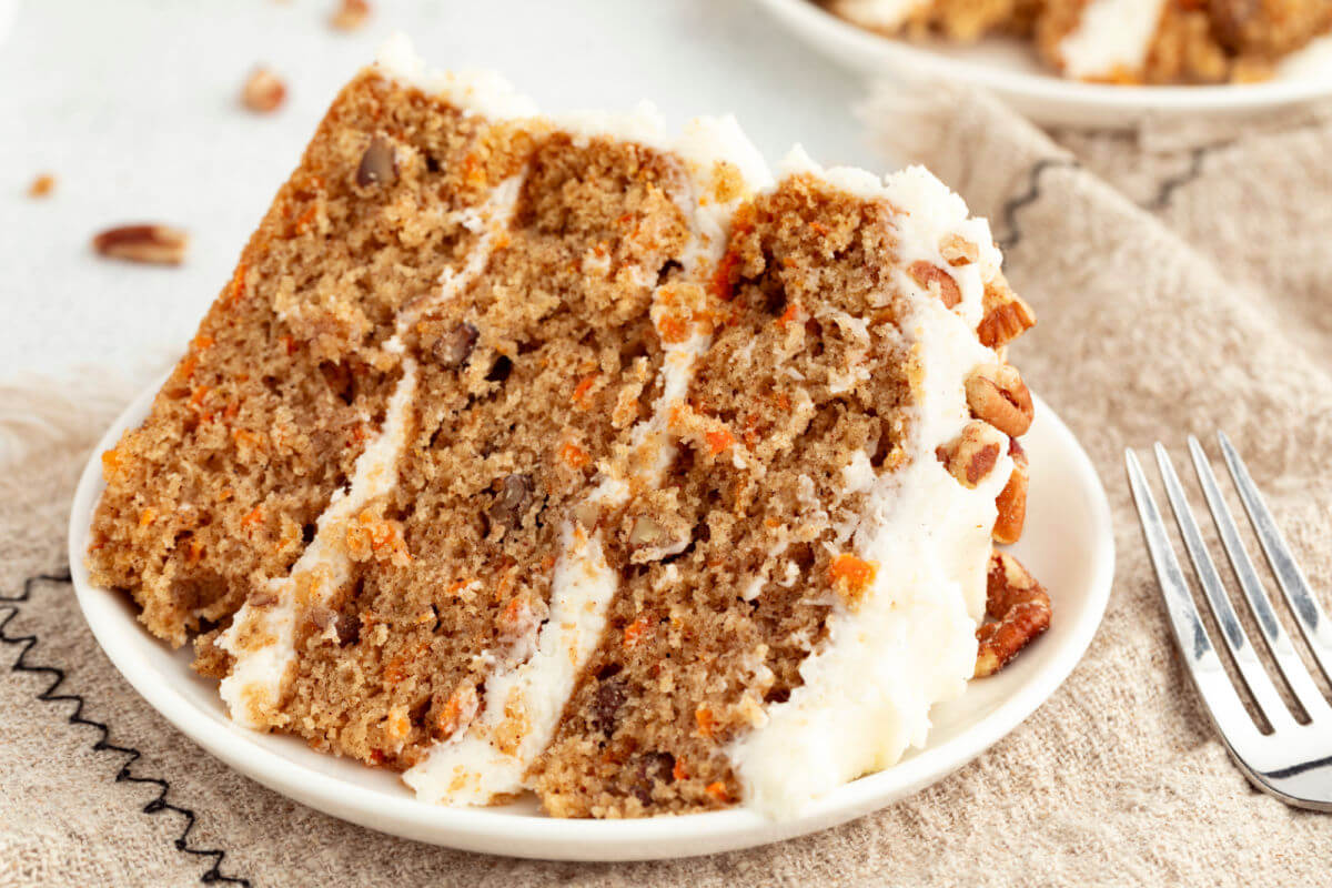 Slice of three-layer sourdough carrot cake on a plate.