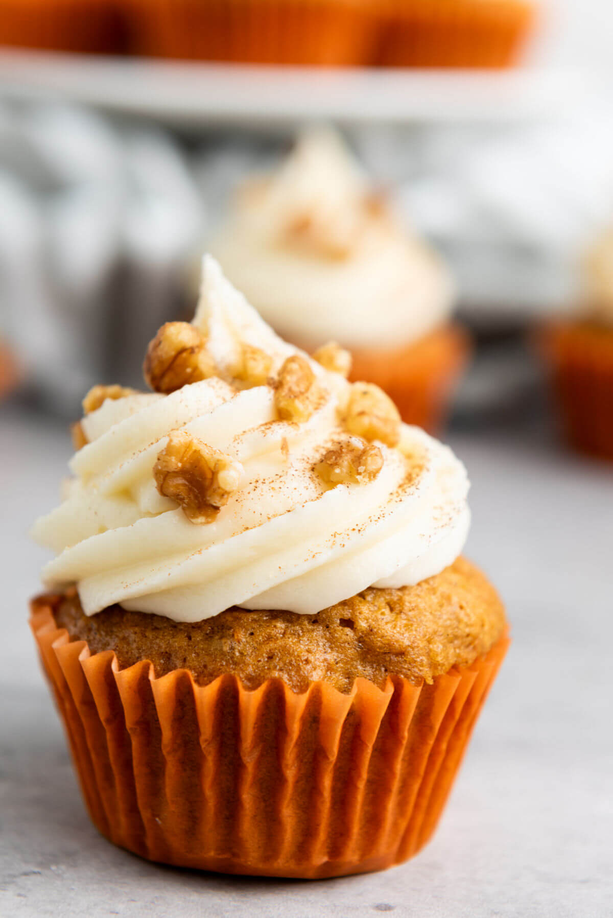 a carrot cupcake with cream cheese frosting with nuts