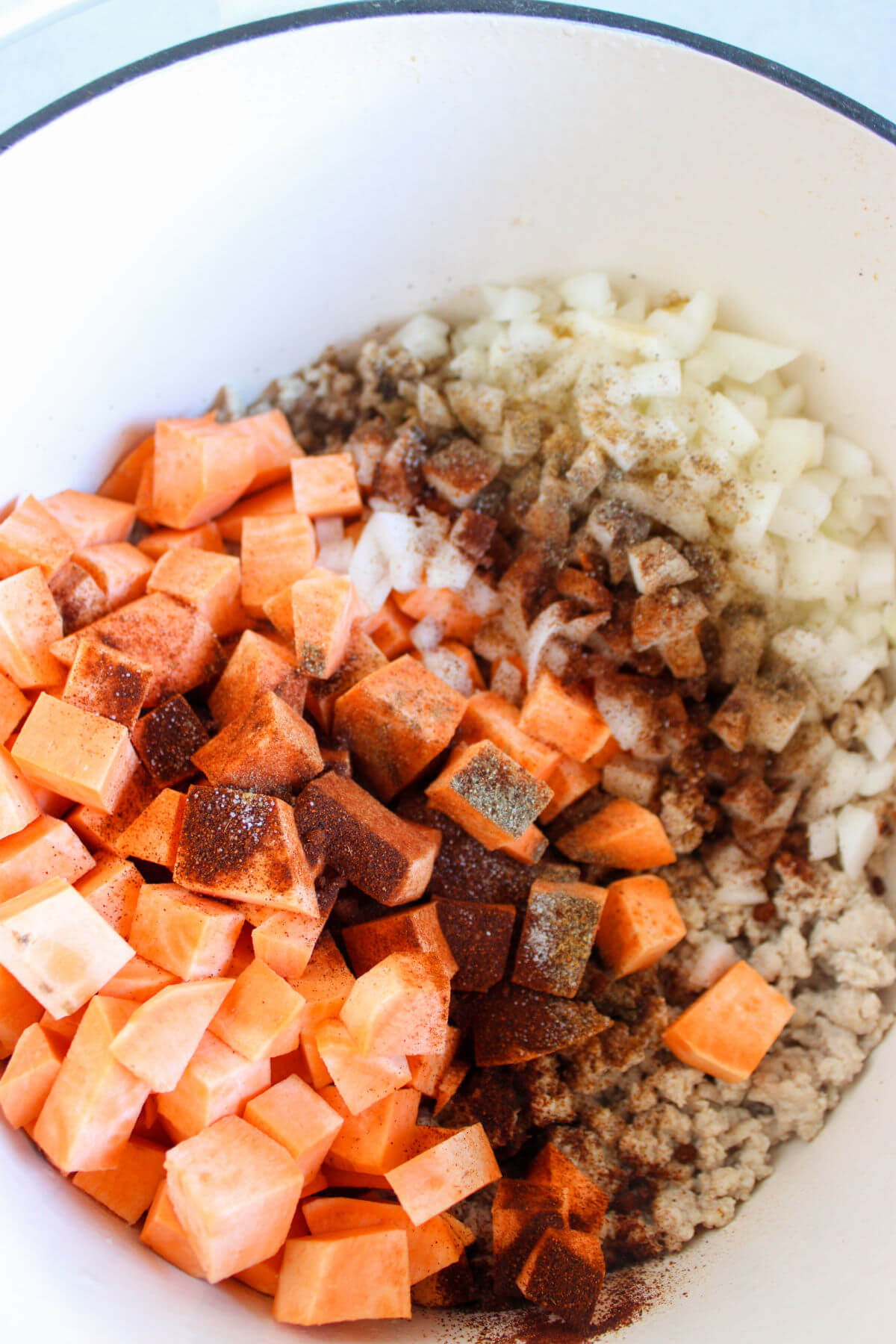 Sweet potatoes, chicken and onion added to Dutch oven.