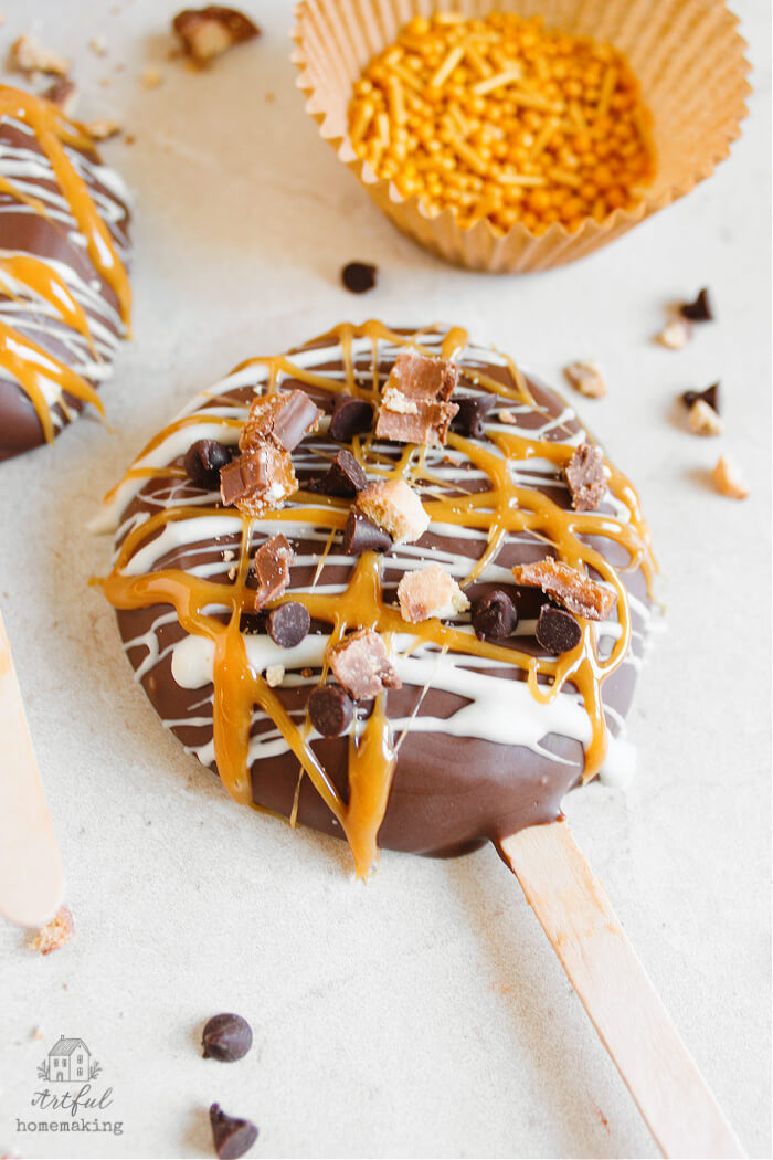 chocolate covered apple slice with caramel and chocolate chips drizzled on it