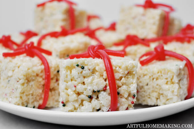rice krispie treats tied with red licorice bows on a plate