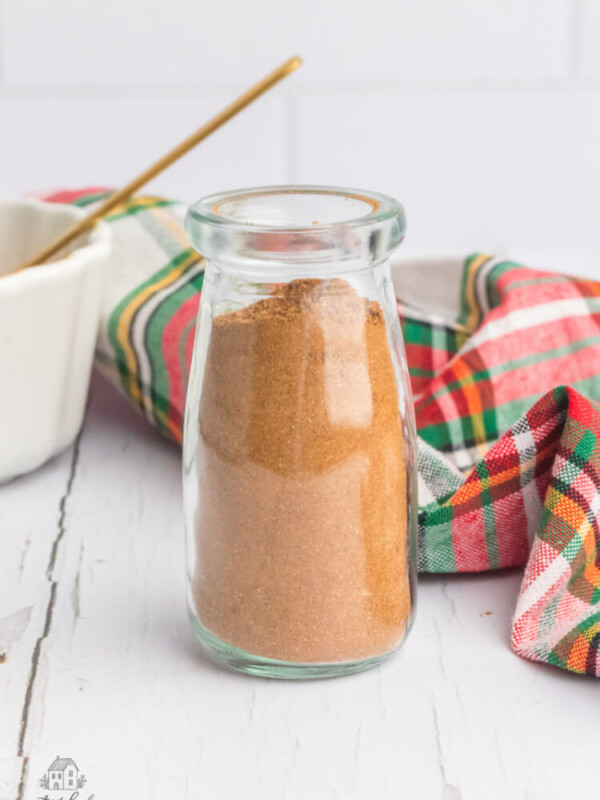 Christmas spice mix in a glass jar on a white wooden table