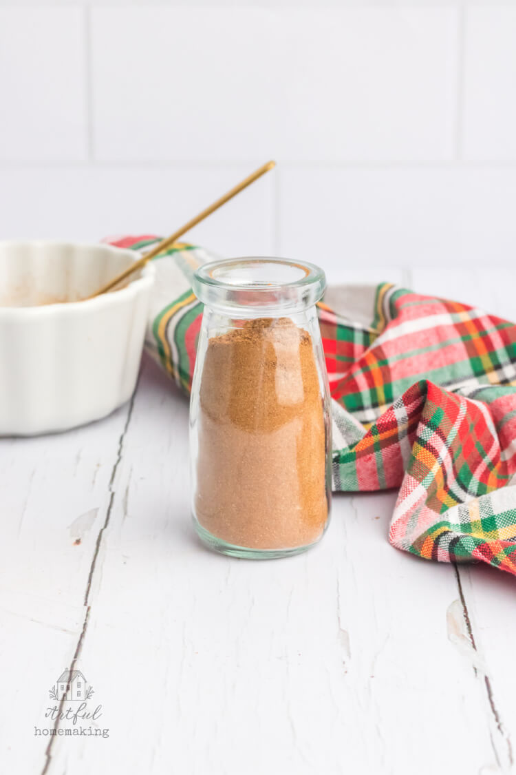 christmas spice mix in a glass spice jar on a white table