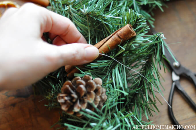 attaching cinnamon stick to wreath