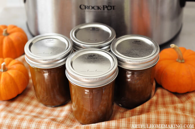 slow cooker pumpkin butter in jars in front of a crock pot