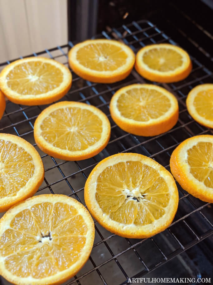 orange slices on wire rack going into the oven