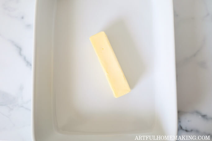 baking dish with a stick of butter in it