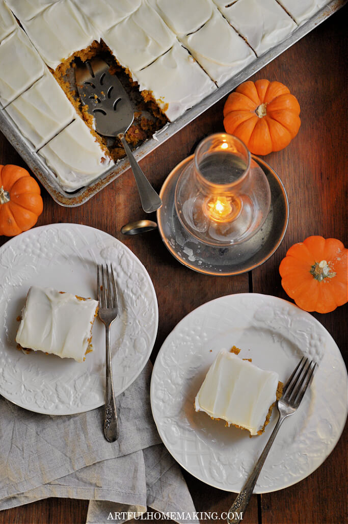 pumpkin bars on white plates with candle on table