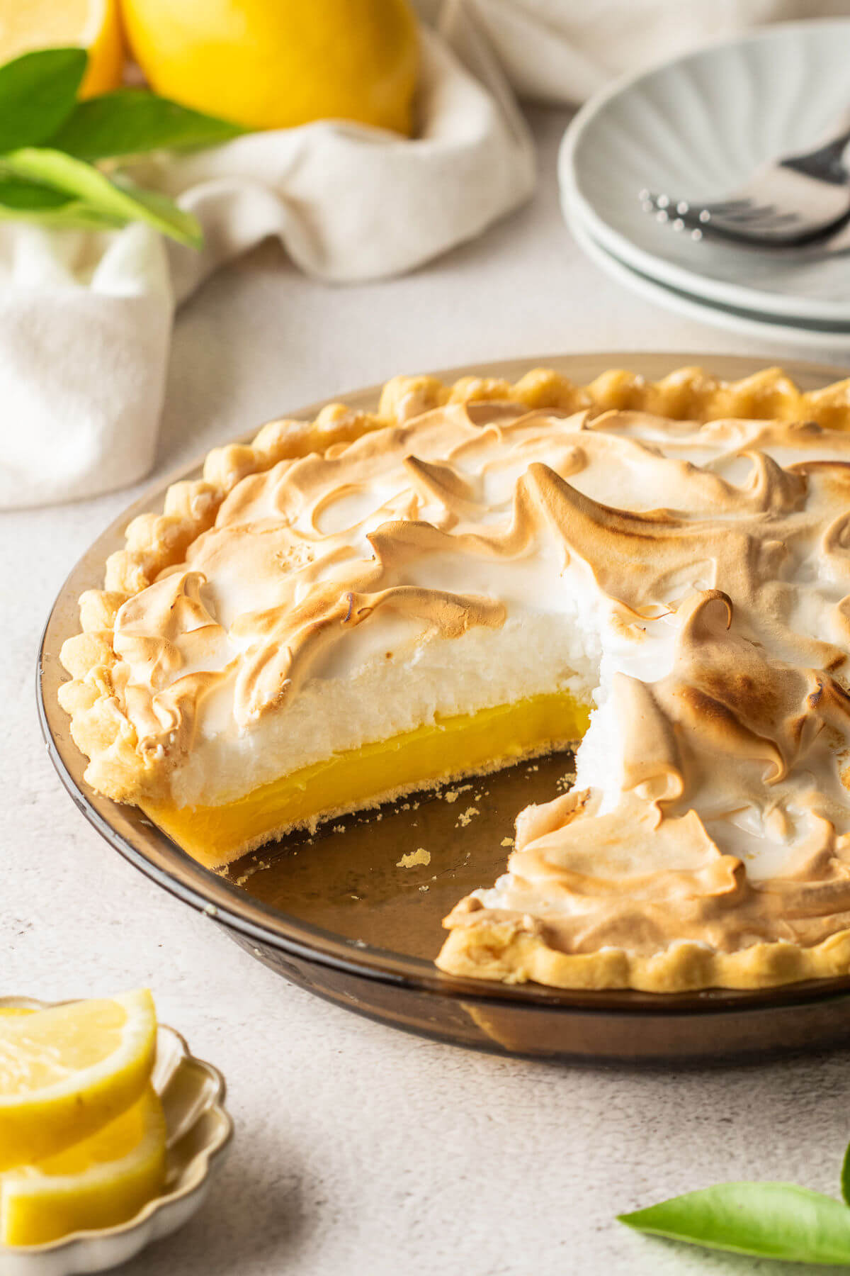 Lemon meringue pie with a slice cut out of it.