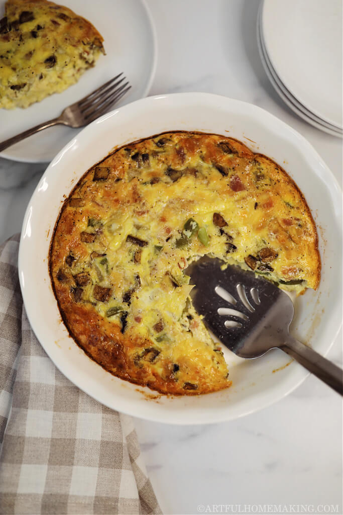 crustless quiche in a white ceramic pie dish being served