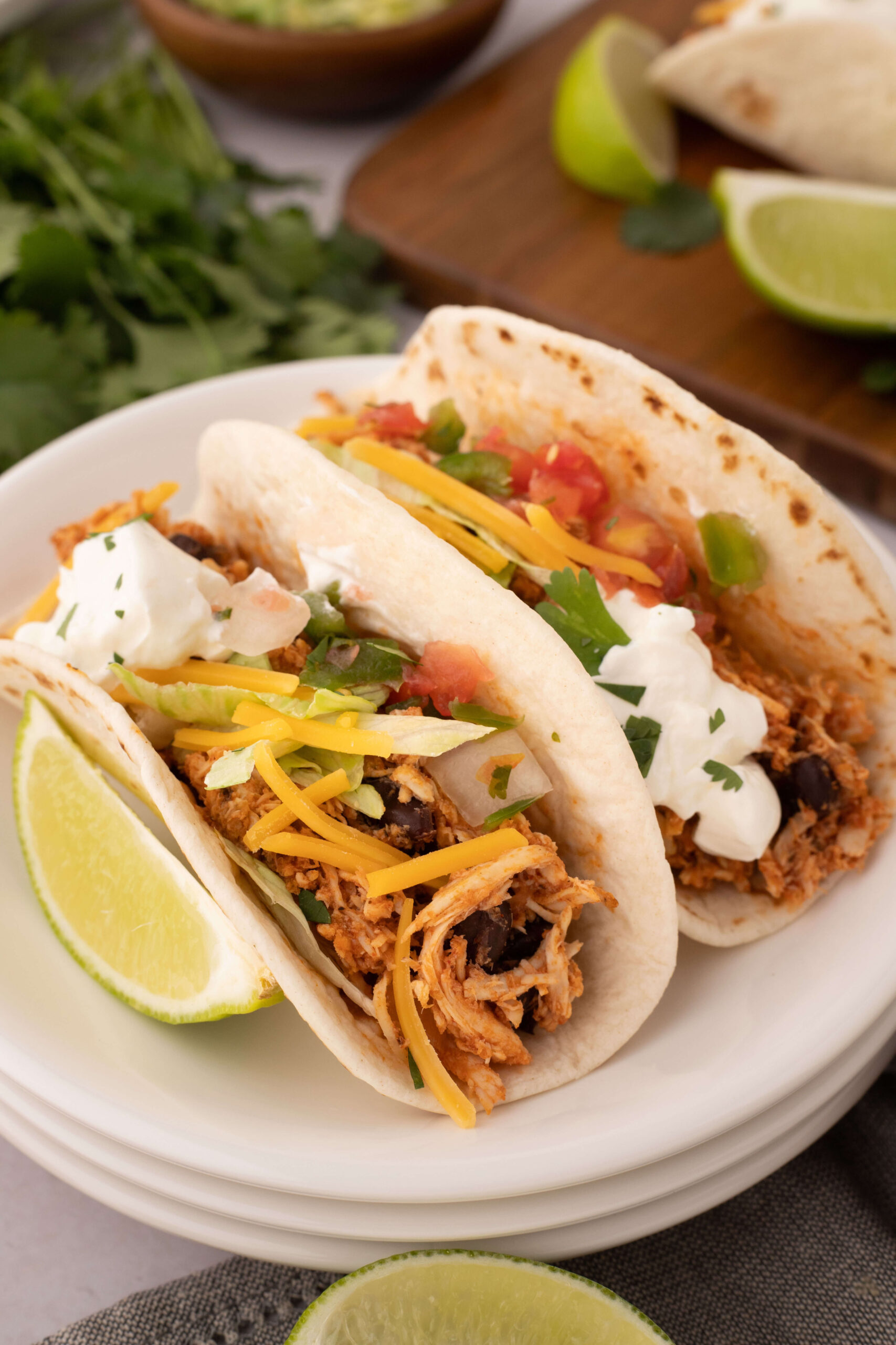 Two rotisserie chicken tacos on a plate.