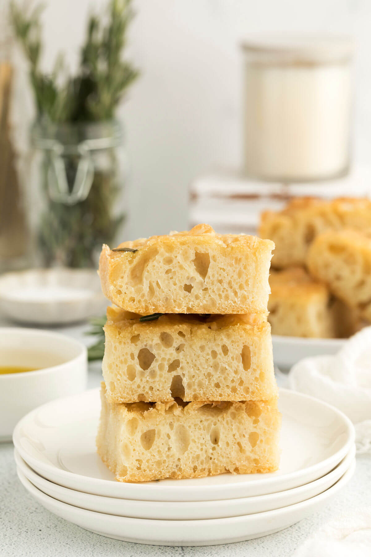 three slices of sourdough focaccia bread on a white plate