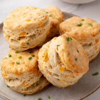 Pile of sourdough cheddar biscuits on a plate.