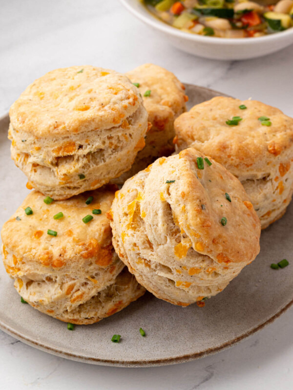 Pile of sourdough cheddar biscuits on a plate.
