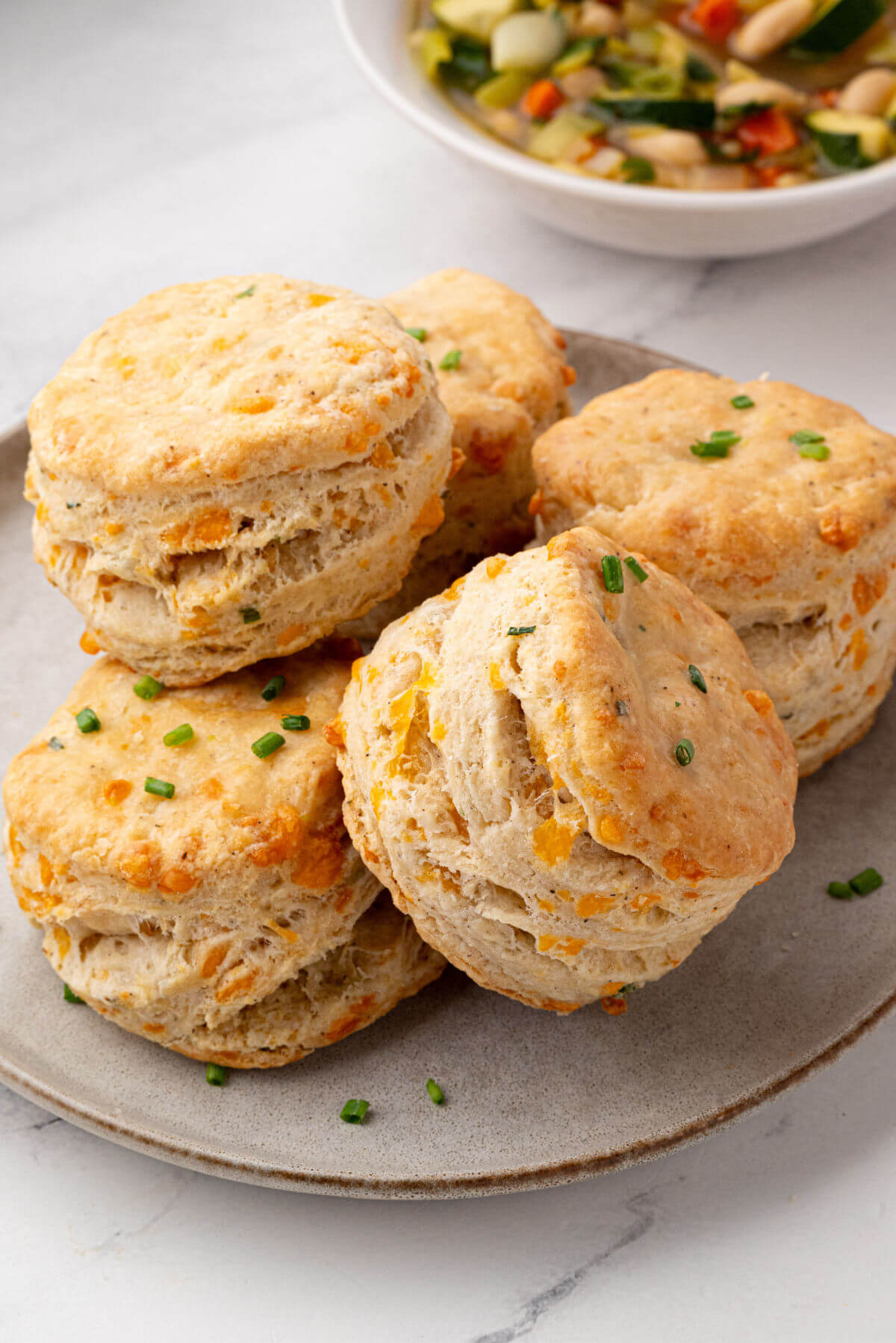 Pile of sourdough cheddar biscuits on a plate.