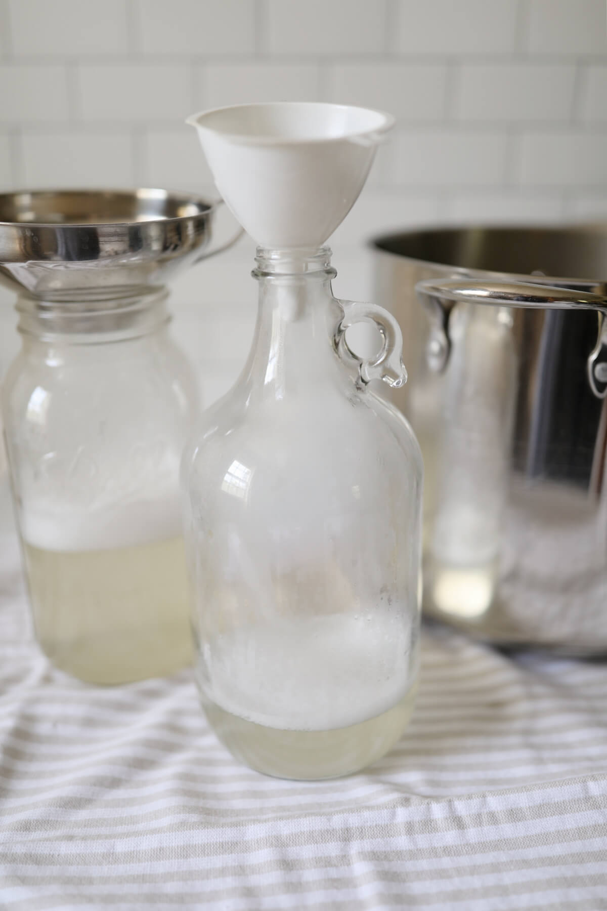 Transferring homemade liquid laundry detergent to half gallon glass jars.