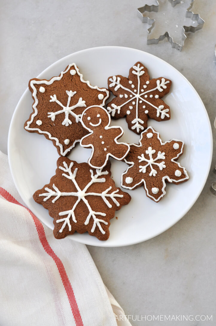 gingerbread christmas cookies on a white plate with a cookie cutter