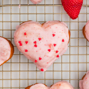strawberry heart shaped donuts with strawberry glaze on a metal cooling rack