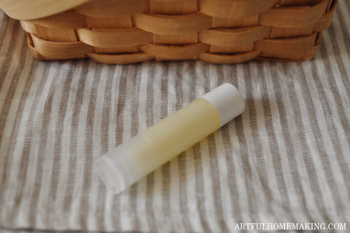 one tube of homemade lip balm on a striped linen towel