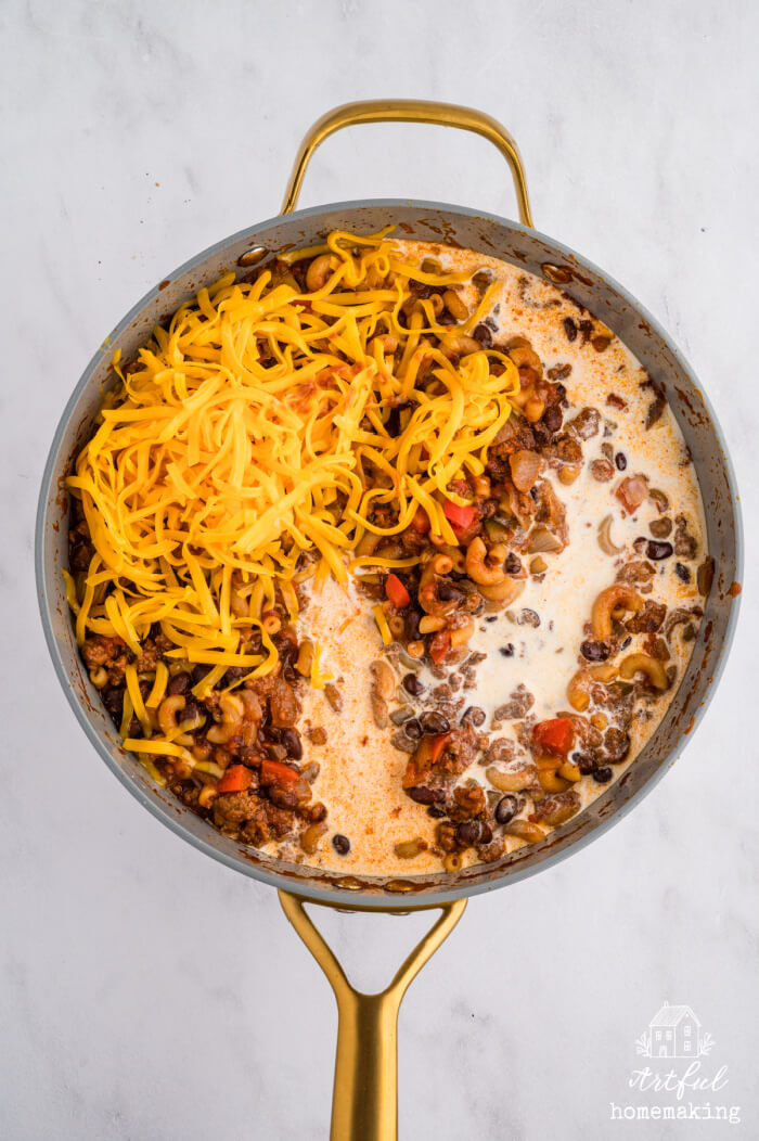 skillet with one pot chili mac and cheese with cream poured around it