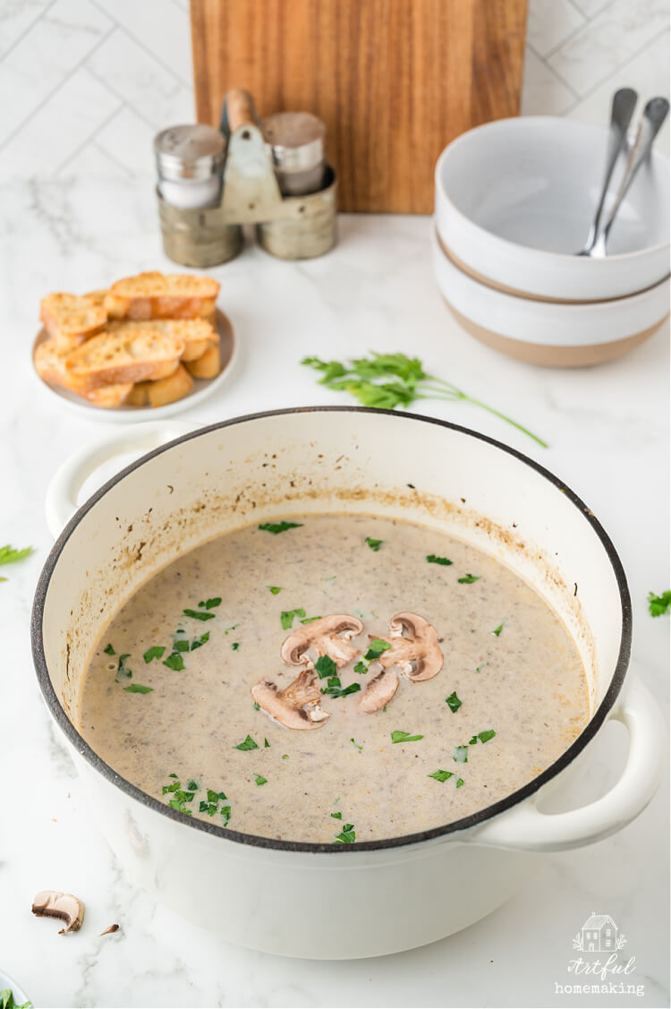 a white pot half filled with mushroom soup