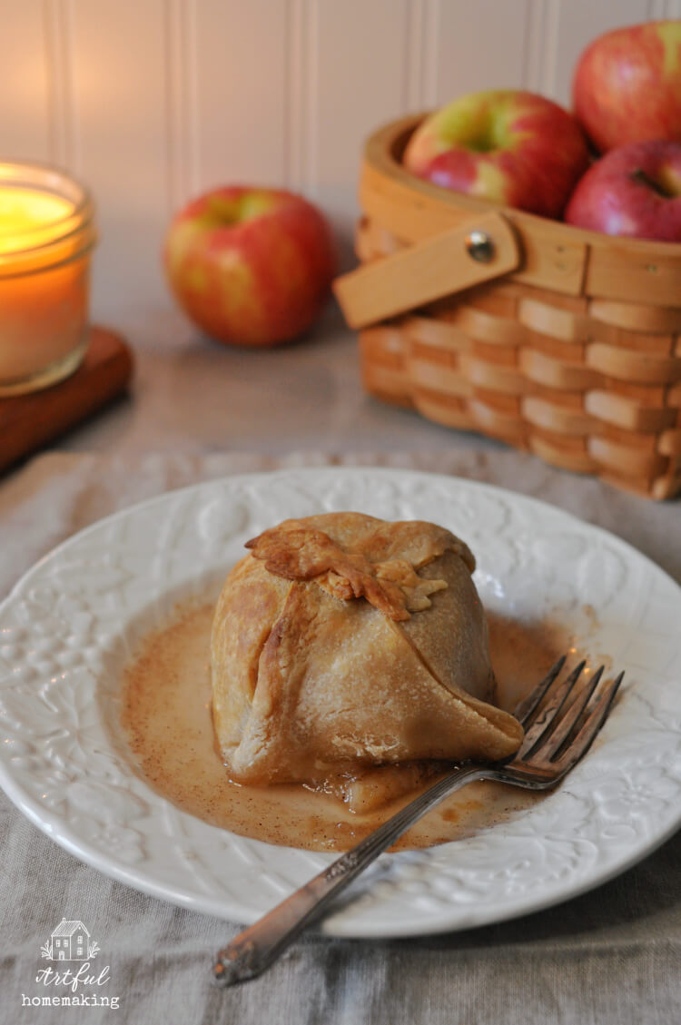 sourdough apple dumpling on a plate with syrup around it and a fork
