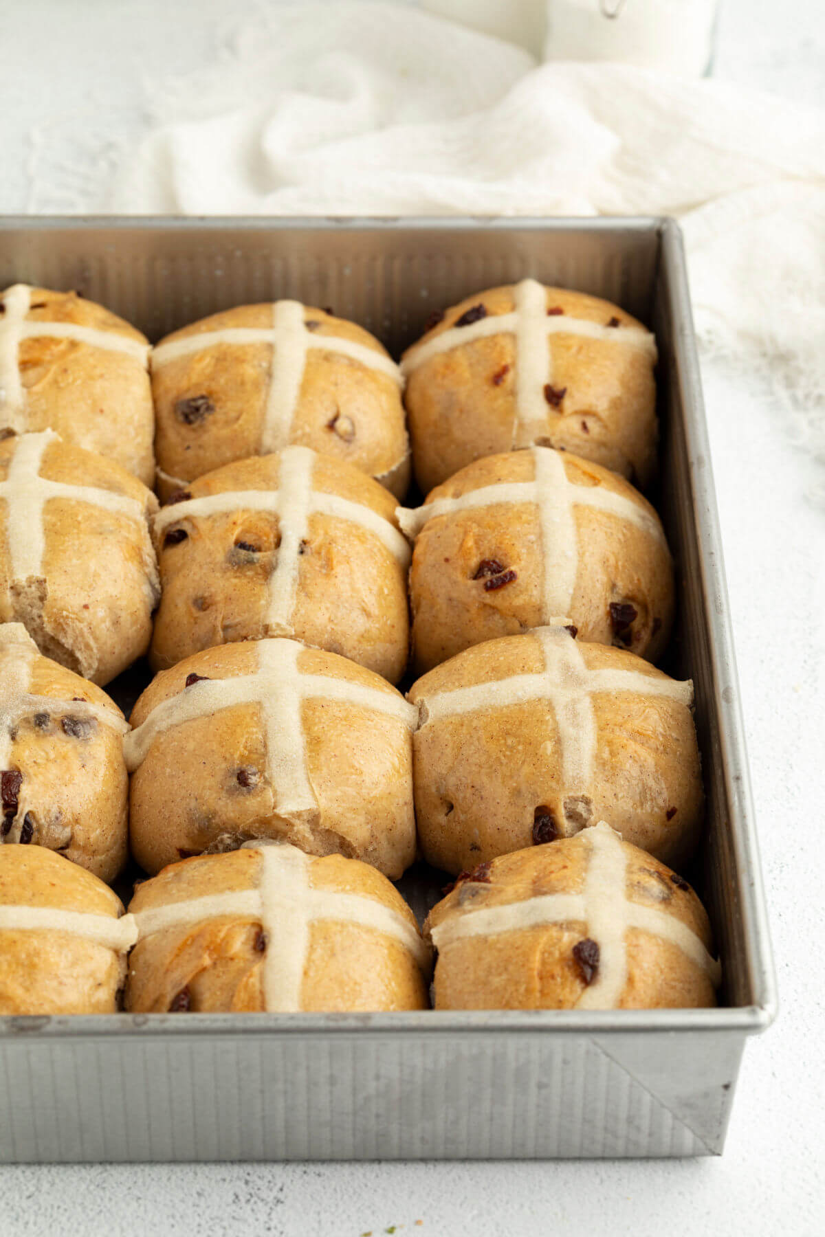 Photo showing a pan of sourdough hot cross buns after baking.