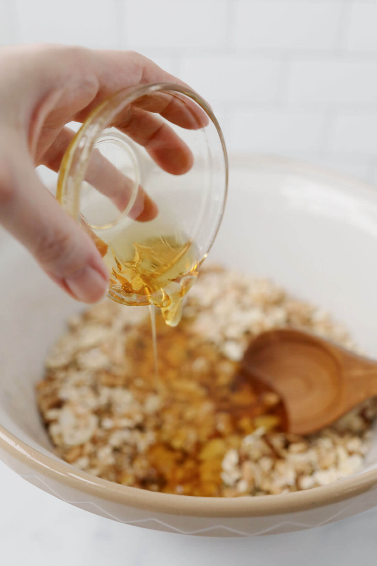 Adding honey to the sourdough granola dry ingredients.