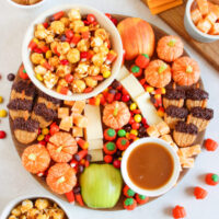 fall dessert charcuterie board with apples, caramel corn, and candy