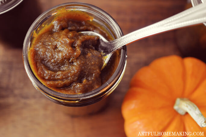 open jar with spoon in it with pumpkin butter on the spoon