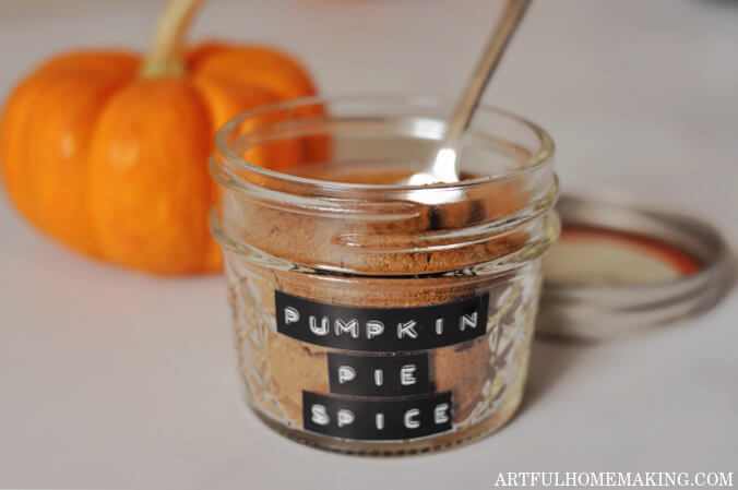 homemade pumpkin pie spice in a glass jar with a spoon and lid next to jar