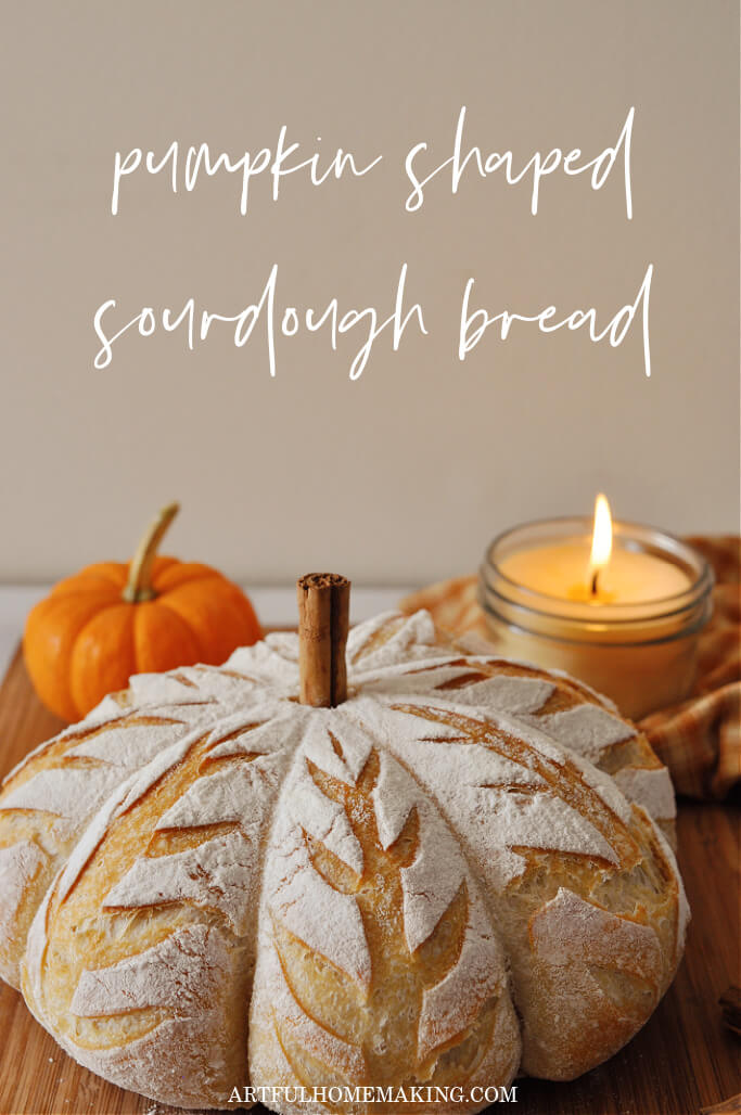 pumpkin shaped sourdough bread with orange mini pumpkin and lit candle