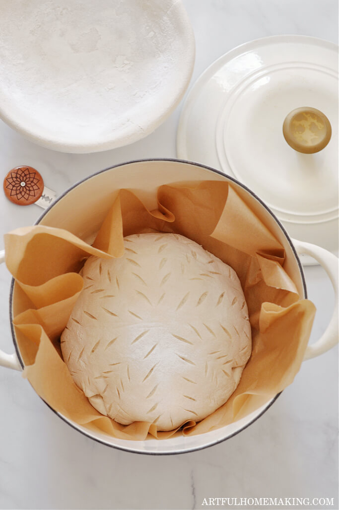 sourdough bread recipe showing scored bread in Dutch oven