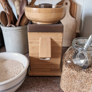 Wooden grain mill with whole wheat berries.