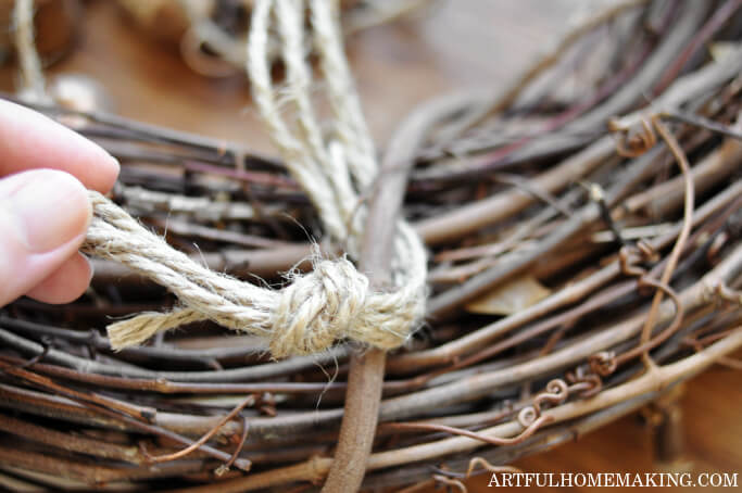 tying bells to grapevine wreath