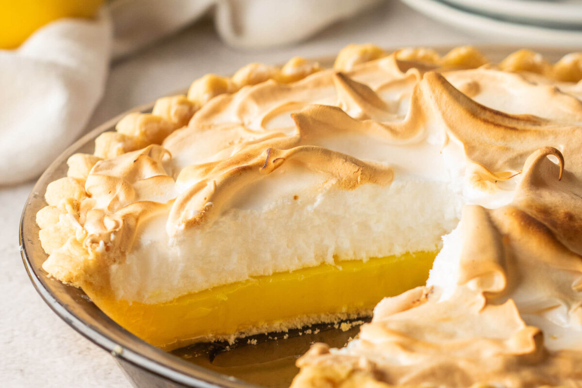 Lemon meringue pie recipe with a slice cut out of the pie.