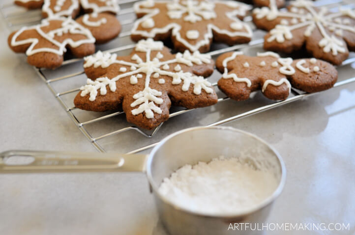 gingerbread cookies made with whole grains on a cooling rack with a cup of powdered sugar