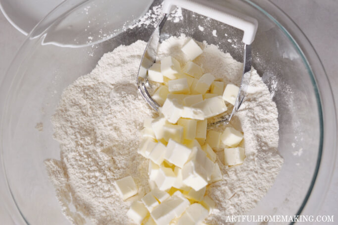 cold butter cubes in a bowl with flour and salt with a pastry cutter blender