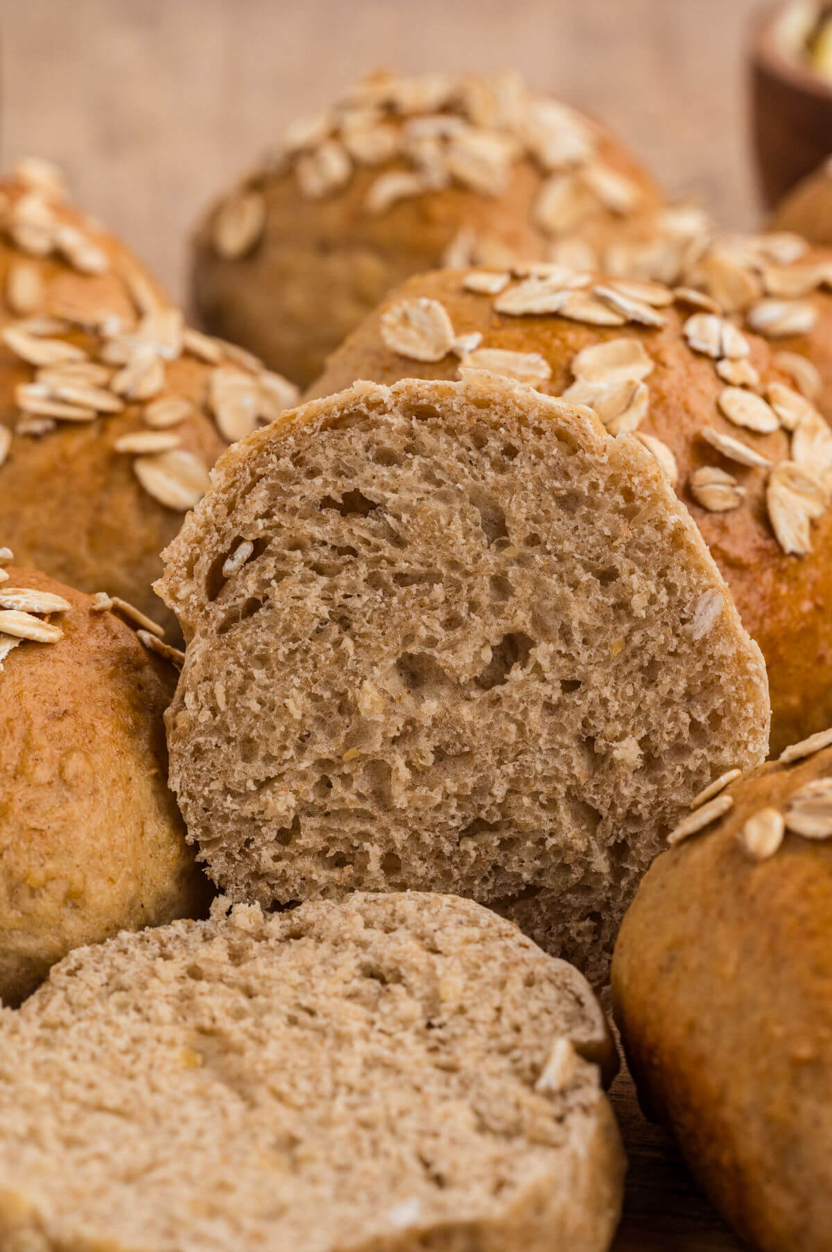 Pile of oatmeal dinner rolls on a plate.