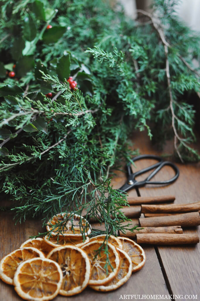 dried orange slices with cinnamon sticks and evergreen boughs