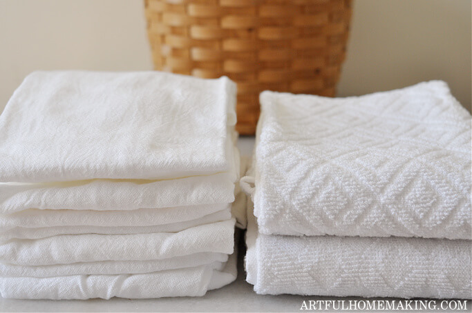 two folded stacks of clean white towels on a table