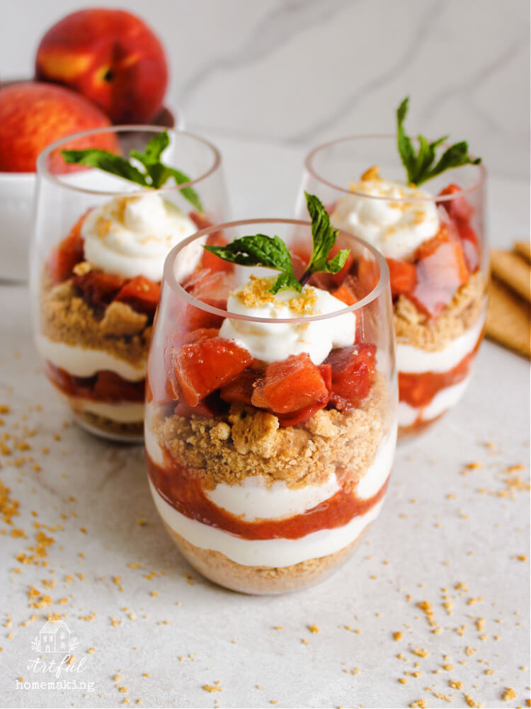peaches and cream parfait in clear glass wine tumblers on a counter