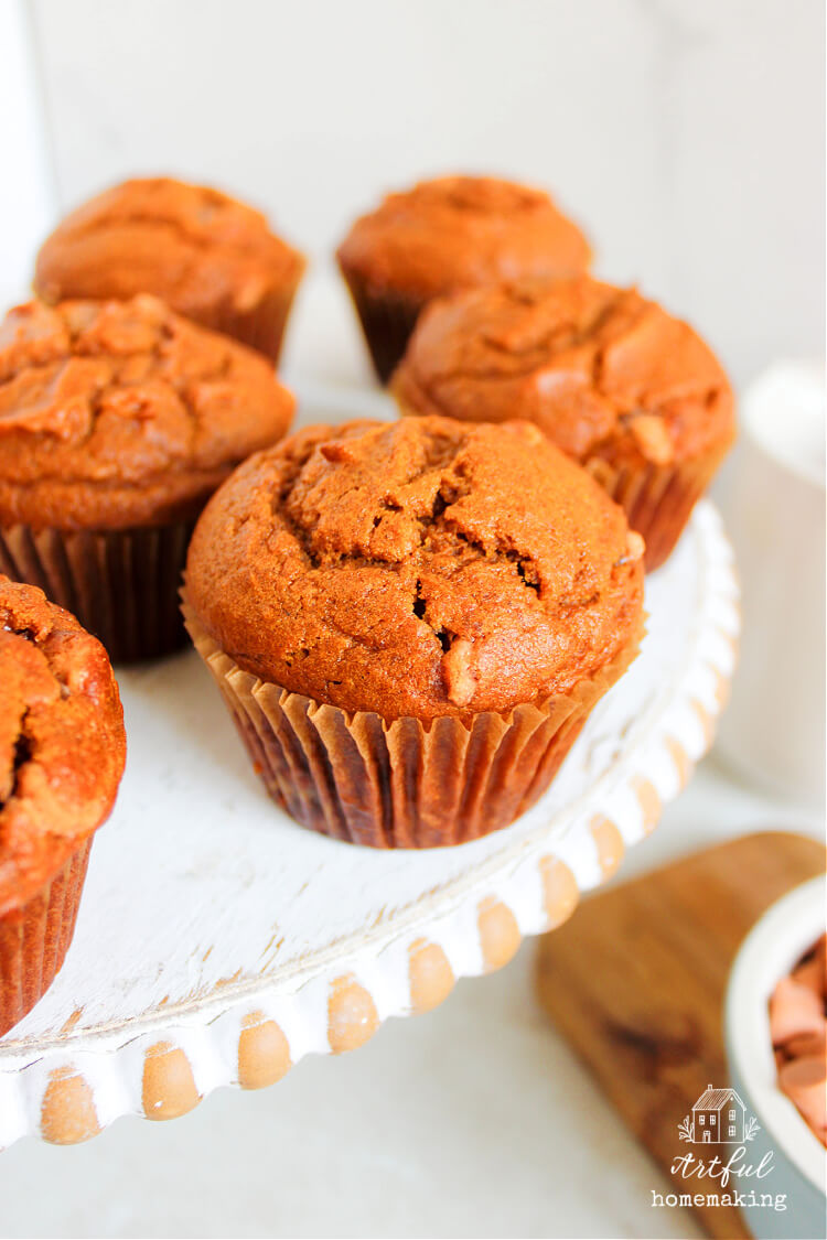 pumpkin butterscotch muffins on a white wooden cake stand