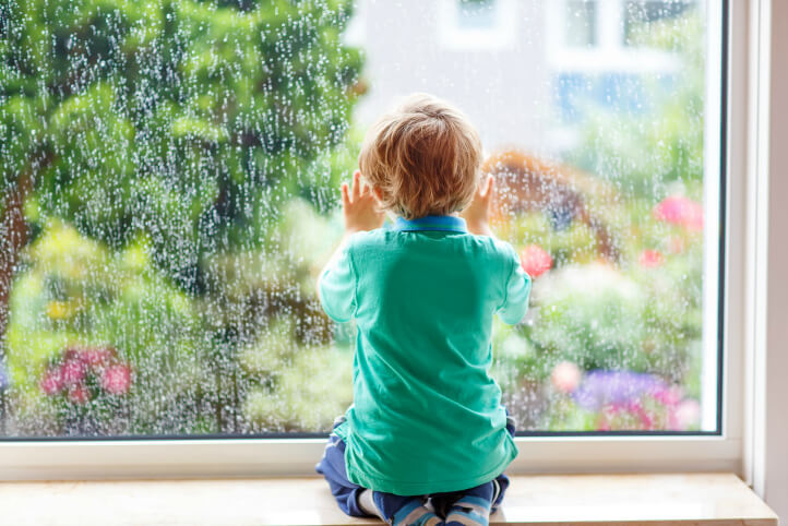 child looking outside window rainy day