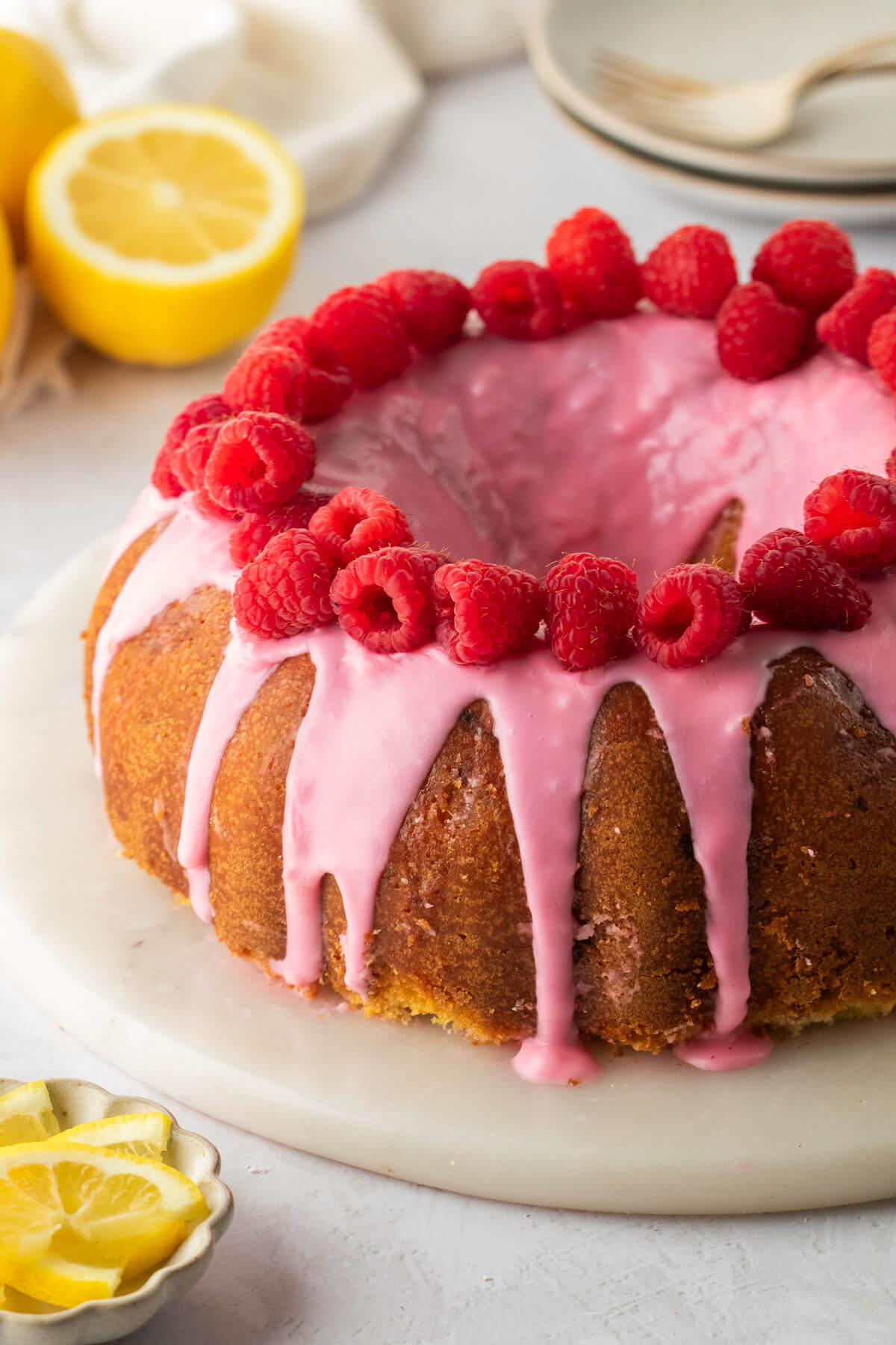 Lemon raspberry bundt cake with raspberry glaze and raspberries on top.