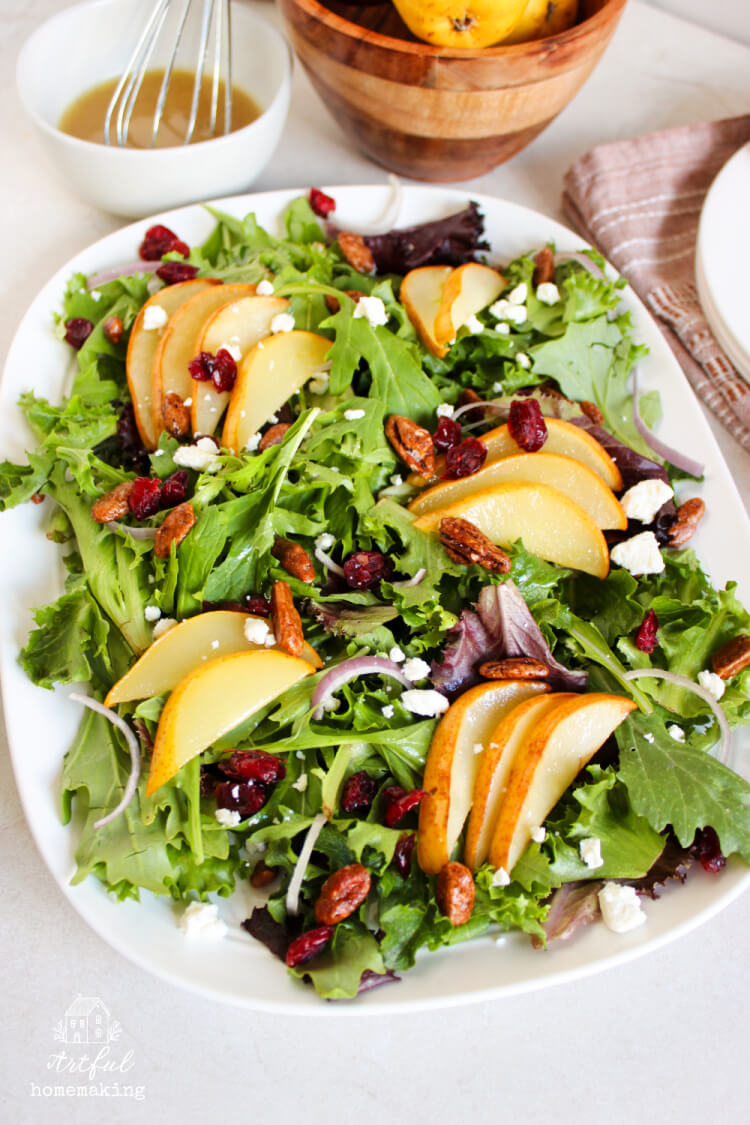 roasted pear salad with homemade dressing and cranberries on a white serving platter