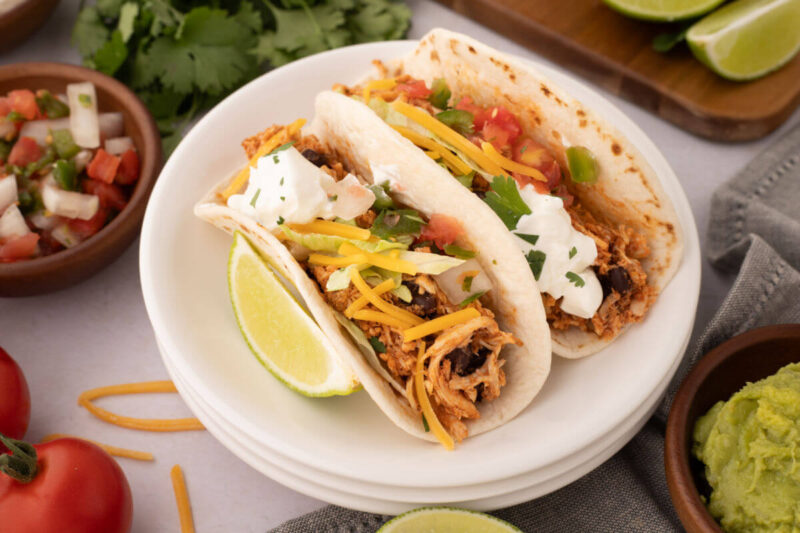 Two rotisserie chicken tacos on a plate.