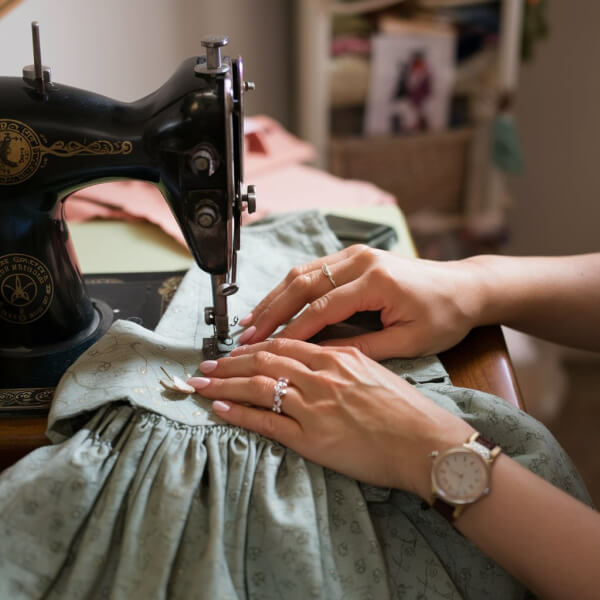 a woman sewing a vintage dress