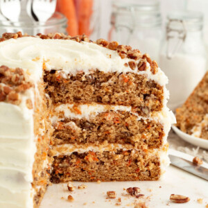 Three layer sourdough carrot cake with slices cut out of it.